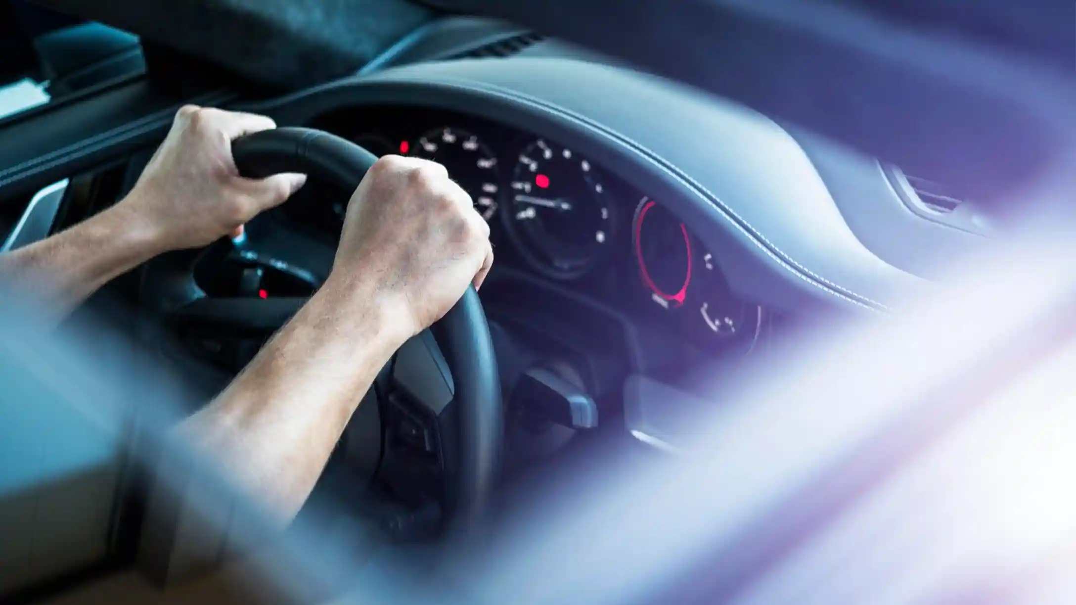 Persona con las manos en el volante de un auto