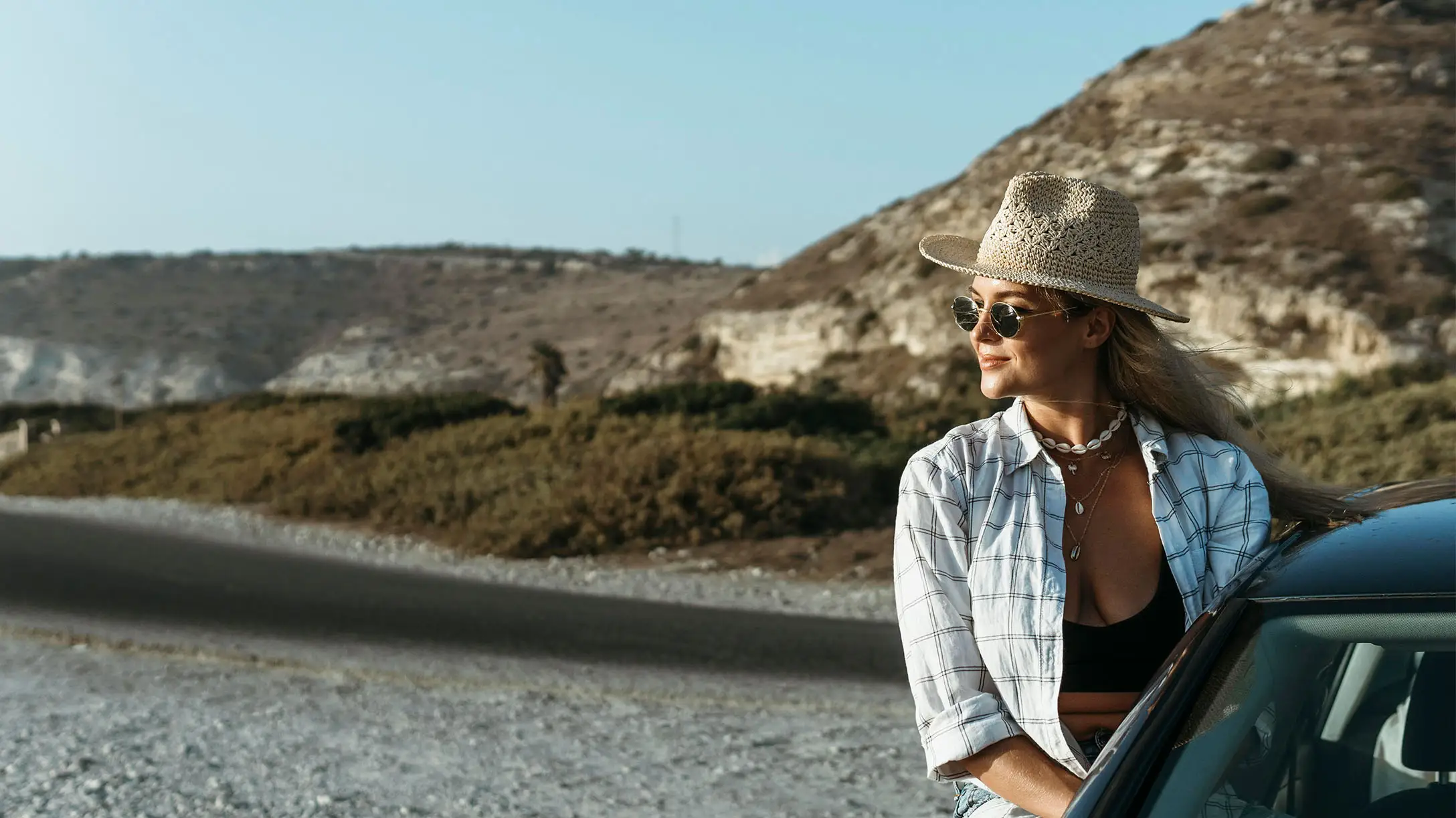 Mujer en un automovil en un terreno rocoso